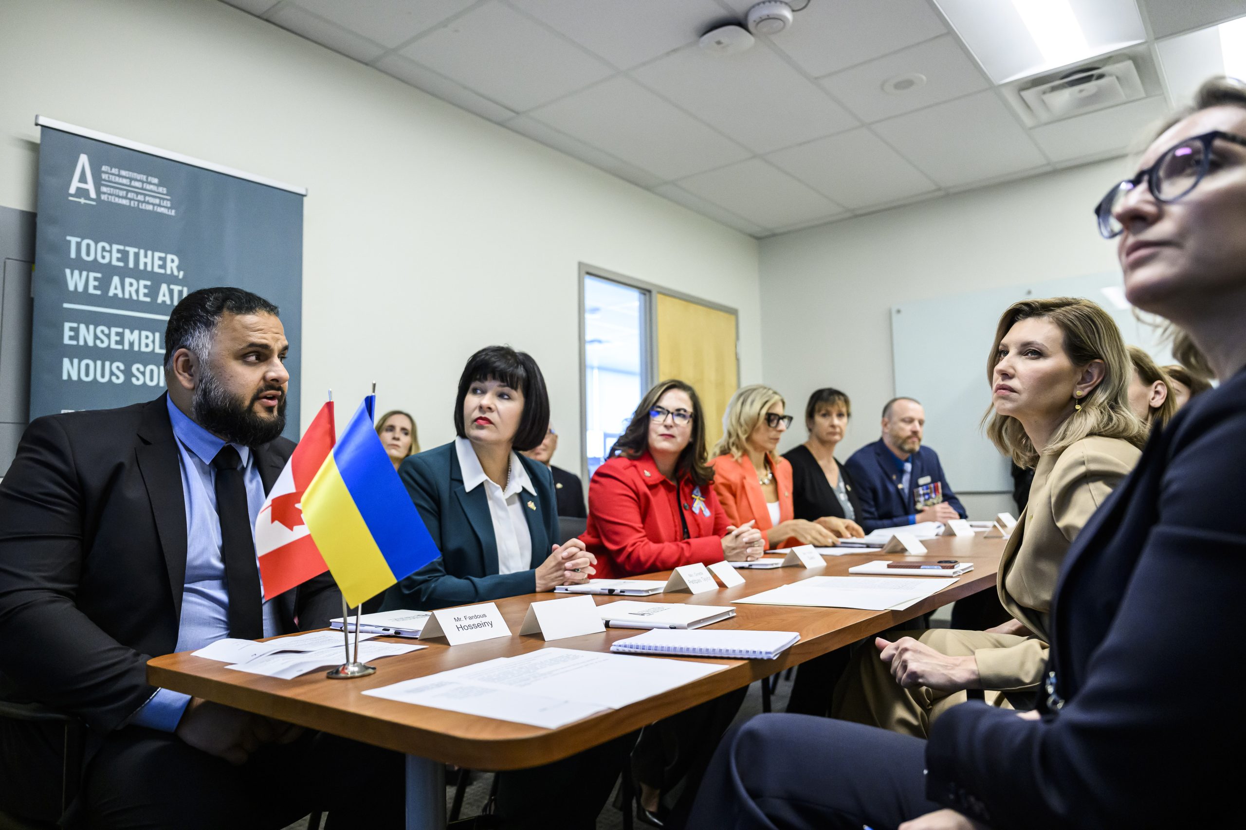 En septembre 2023, Atlas a signé un protocole d'entente officialisant un partenariat avec le centre Lisova Polyana pour la santé mentale et la réadaptation des vétérans en Ukraine. De gauche à droite : Fardous Hosseiny, président et chef de la direction d'Atlas; l'honorable Ginette Petitpas Taylor, ministre des Anciens Combattants du Canada; l'honorable Ya'ara Saks, ministre de la Santé mentale et de la dépendance; MaryAnn Notarianni, cheffe de la direction adjointe d'Atlas; Laryssa Lamrock, conseillère stratégique nationale, familles; Brian McKenna, conseiller stratégique national, vétérans; Olena Zelenska, première dame d'Ukraine. — À l'arrière : Ashlee Mulligan, directrice des partenariats et des relations avec les intervenants; Cal Crocker, président du conseil d'administration. — Crédit photo : Justin Tang